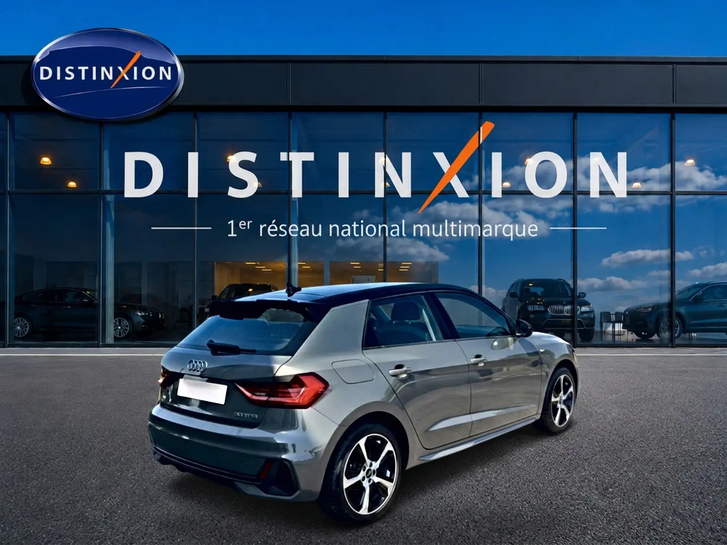 Audi A1 Sportback gris chronos avec toit noir, vue 3/4 arrière droit, jantes alu et becquet arrière visible.