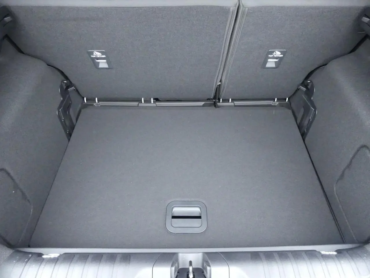 Coffre ouvert vu de dessus du Ford Puma gris métallisé 2025, montrant le plancher plat et les dossiers arrière rabattus.