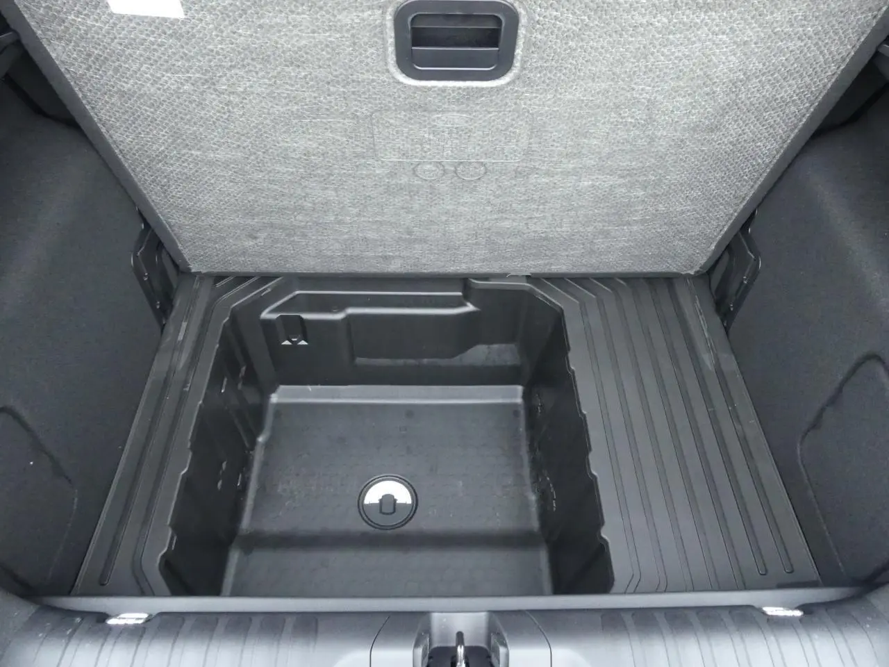 Vue plongeante sur le compartiment de rangement sous le plancher du coffre du Ford Puma gris métallisé 2025.