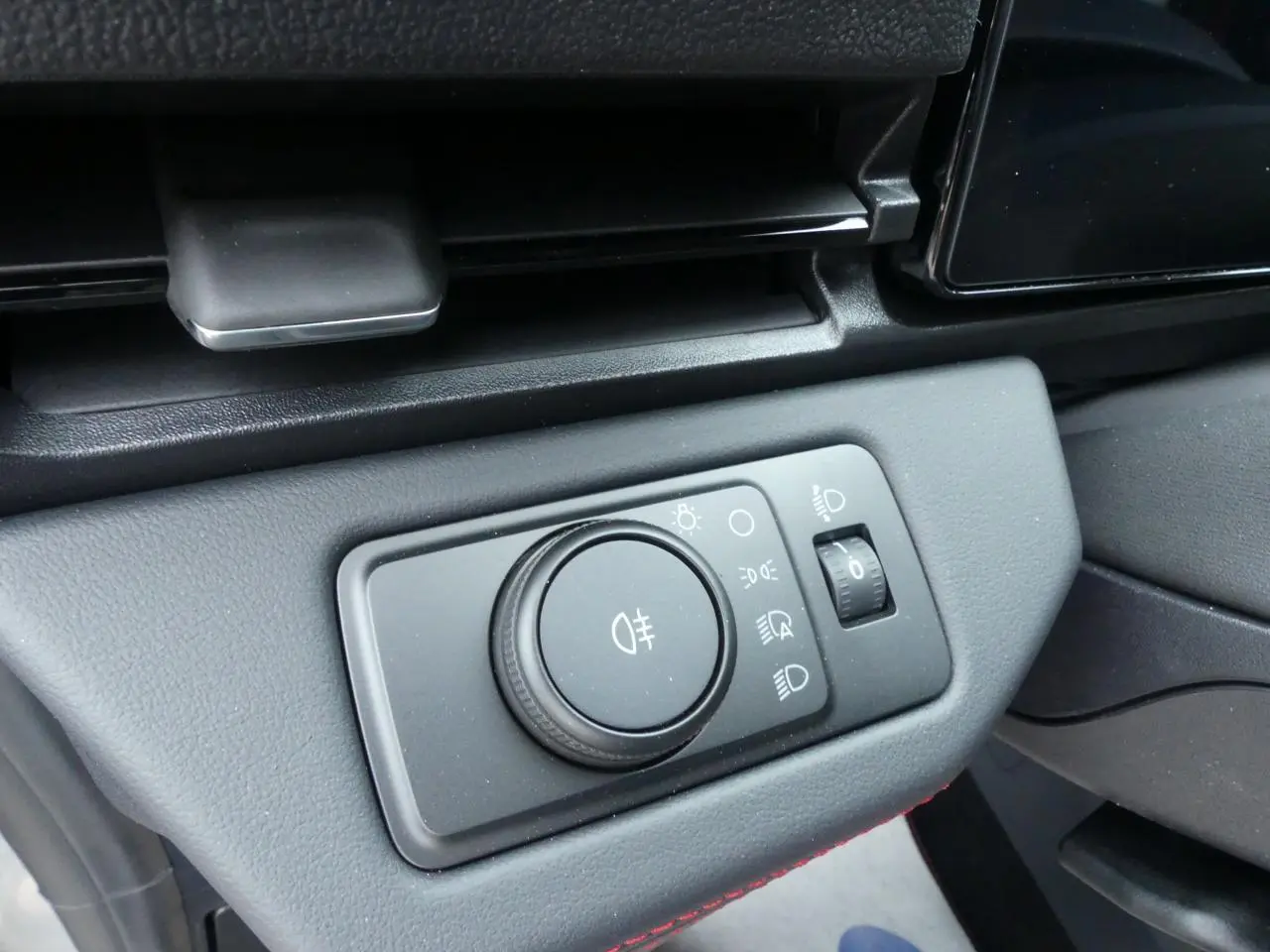 Gros plan sur la commande d'éclairage intérieure du Ford Puma 2025 gris métallisé, avec molette et réglage des phares.