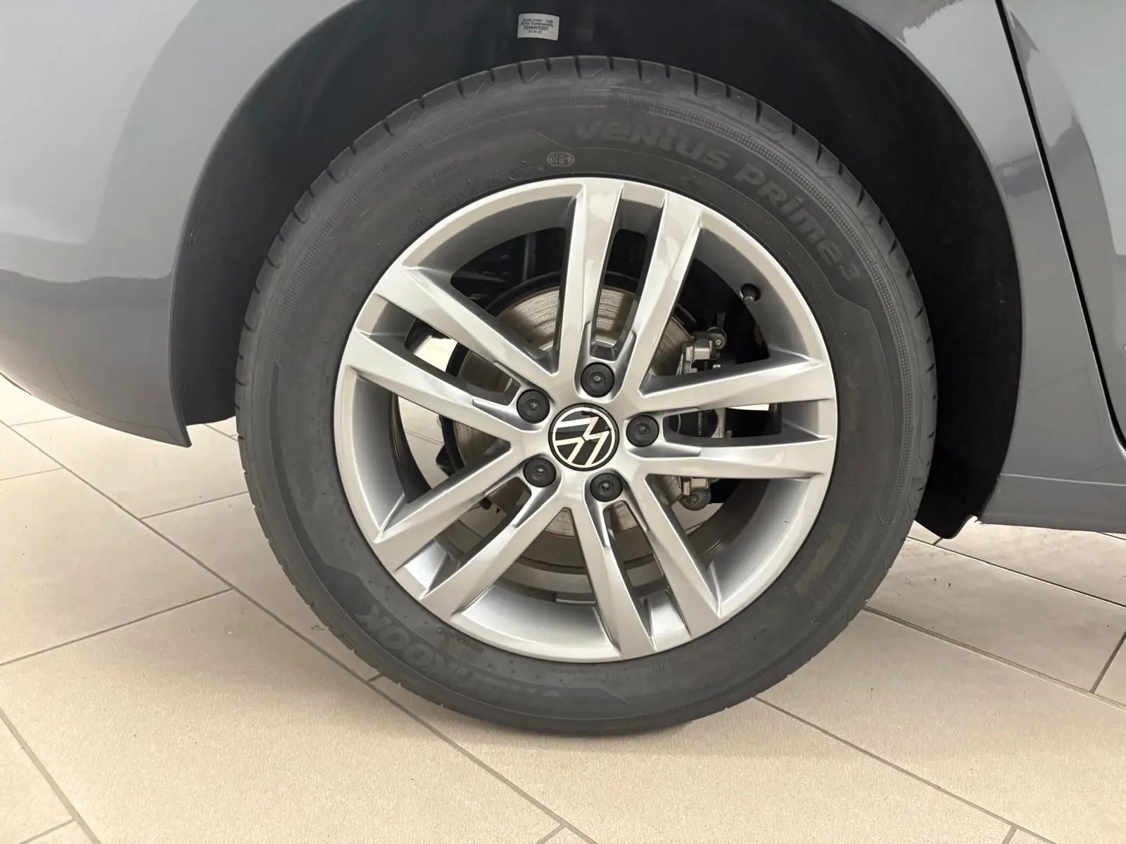 Gros plan sur la jante alliage 17 pouces du Volkswagen Touran gris dauphin, mettant en valeur le logo VW central.