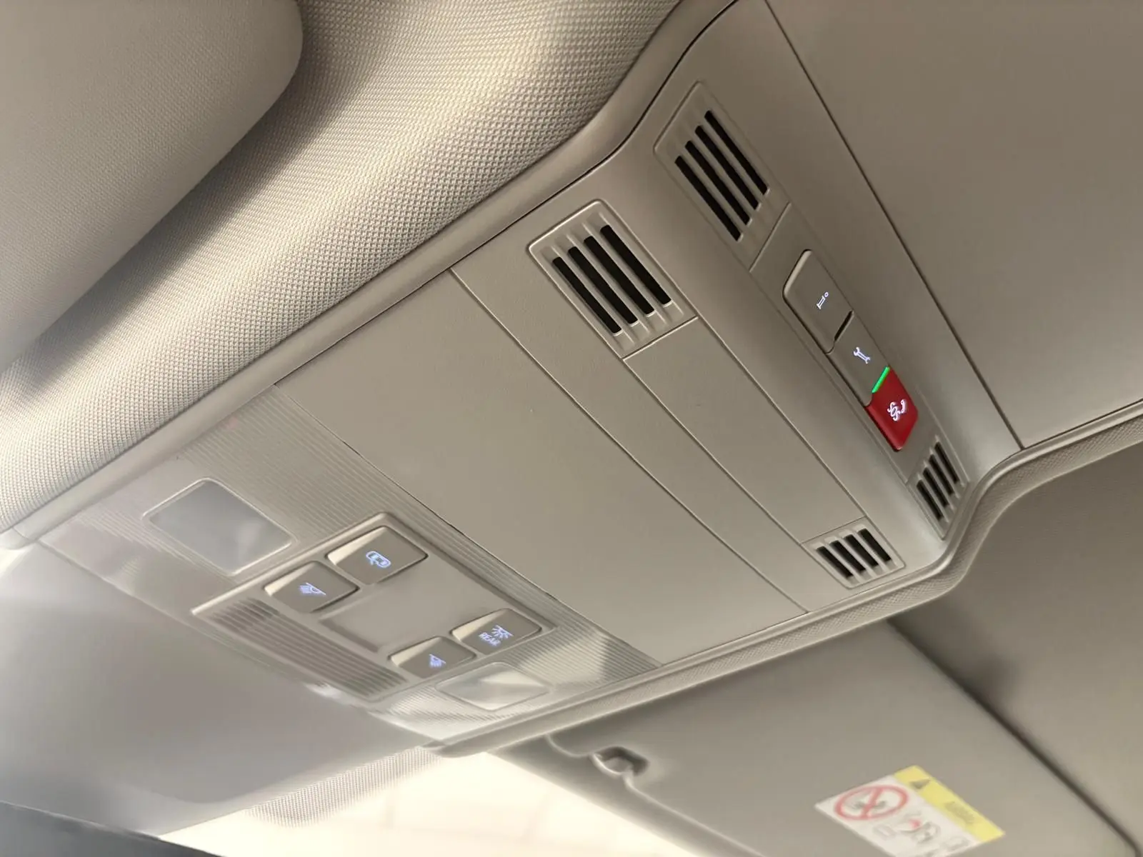 Plafonnier intérieur gris clair du Volkswagen Touran 2025 avec commandes d'éclairage et ventilation intégrées.