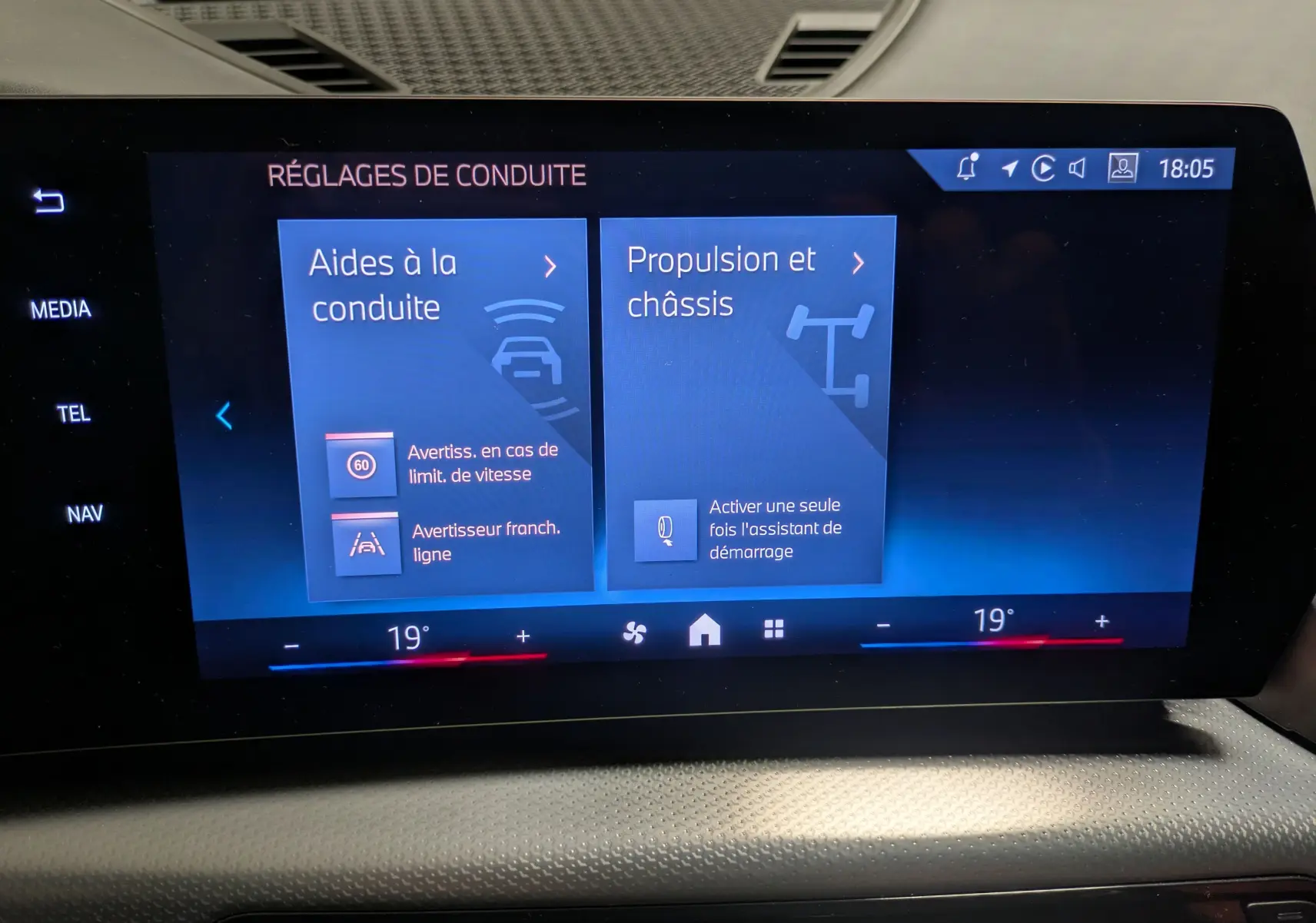 Écran tactile central du BMW X1 blanc 2025 affichant les réglages d’aides à la conduite et propulsion.