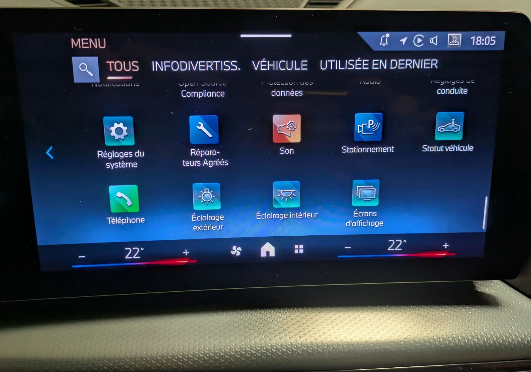 Écran tactile central du BMW X1 blanc 2025 affichant le menu des réglages système et véhicule.