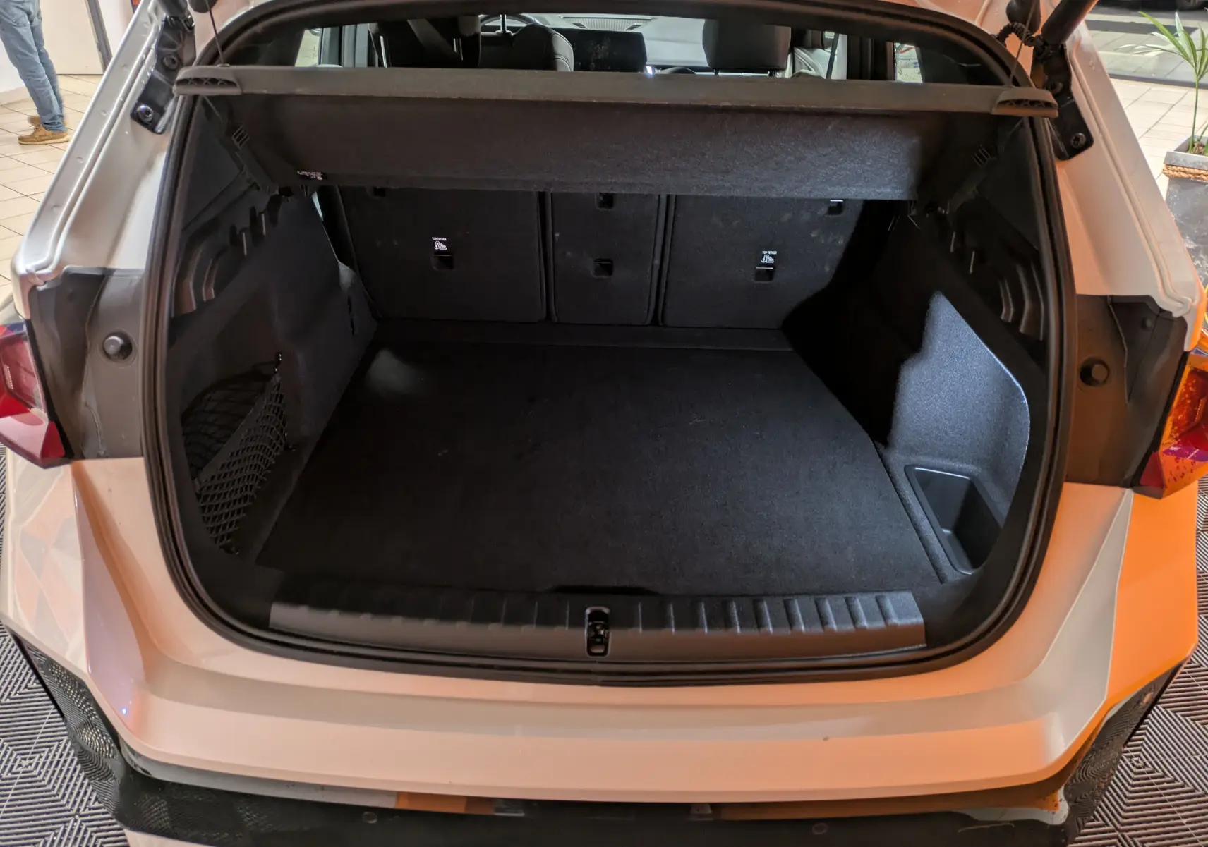 Coffre ouvert vu de l'arrière d'un BMW X1 blanc 2025, montrant un espace de chargement vide et bien fini.