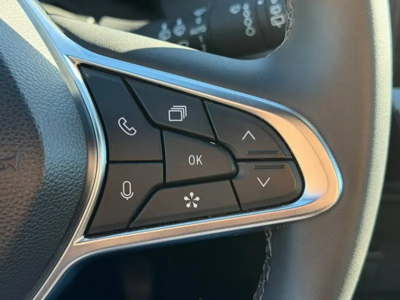 Gros plan sur les commandes multifonctions au volant du Renault Captur 2025, finition Techno, avec boutons noirs et contour chromé.