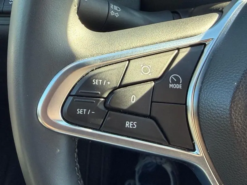 Gros plan sur les commandes de régulateur de vitesse au volant d’un Renault Captur 2025 Rouge Flamme.