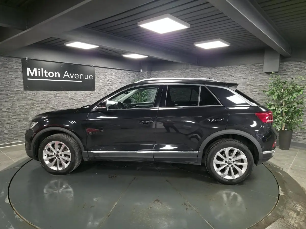 Volkswagen T-Roc noir vue de profil côté gauche dans un showroom avec jantes alliage 17 pouces.