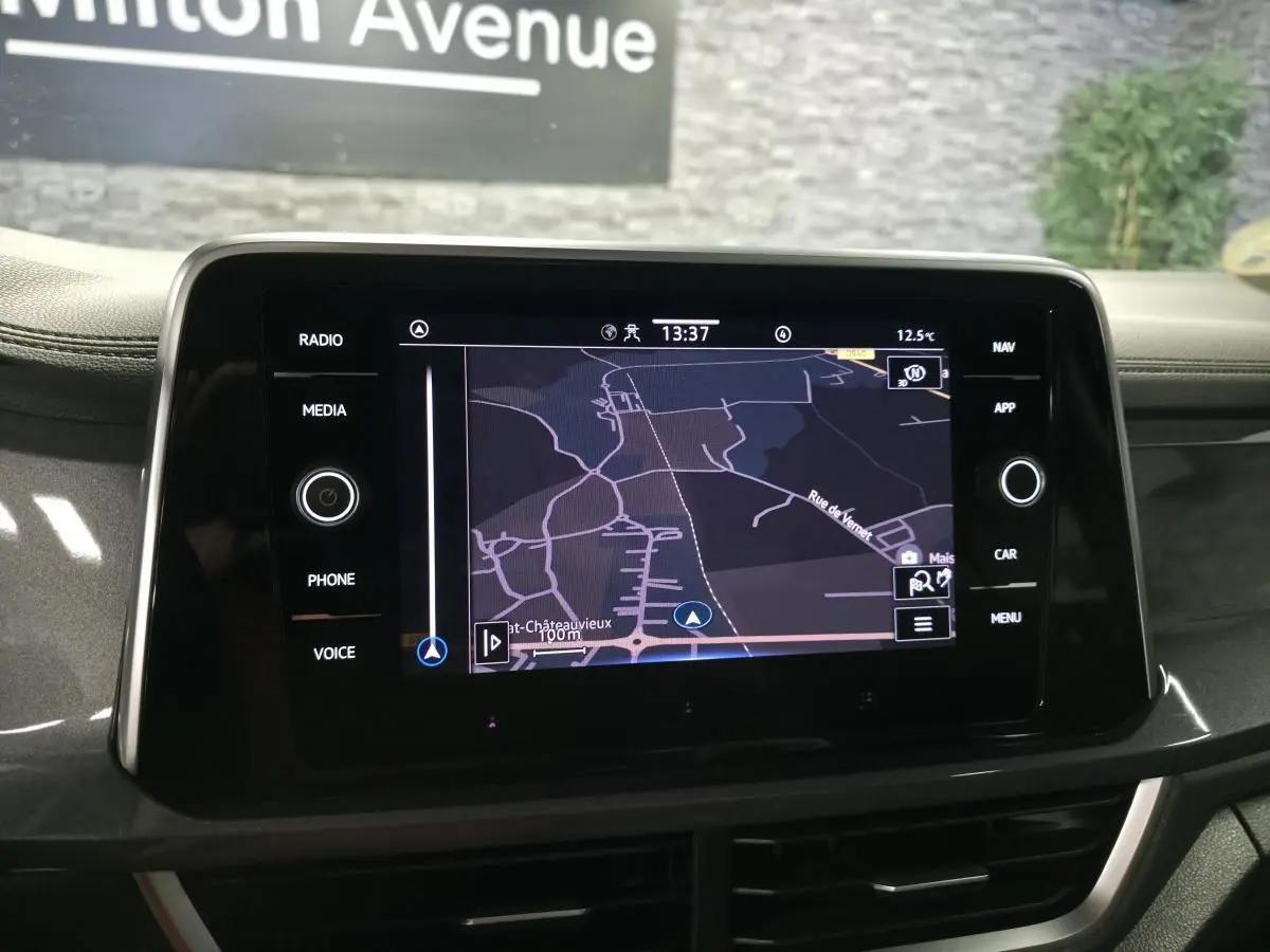 Écran tactile central du Volkswagen T-Roc noir 2022 affichant une carte de navigation, vue intérieure frontale.