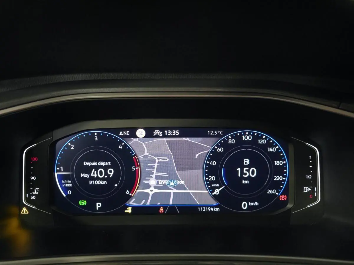 Affichage numérique du tableau de bord du Volkswagen T-Roc 2022, avec carte de navigation et compteurs lumineux bleus.