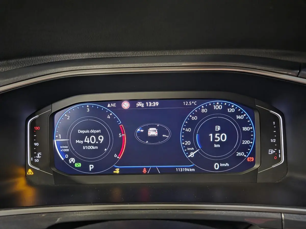 Vue rapprochée du combiné d'instruments digital du Volkswagen T-Roc 2022 affichant la consommation et la distance restante.