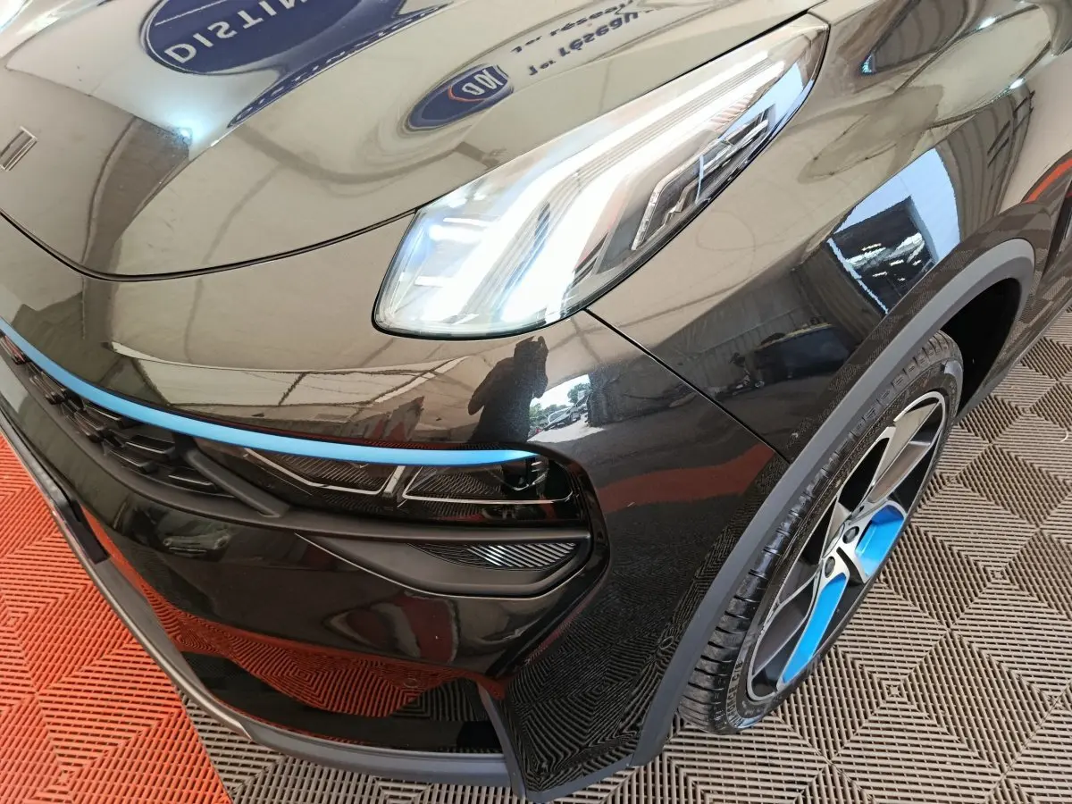 Vue 3/4 avant droit du SUV Link & Co 01 noir avec jante et bande décorative bleue distinctive.