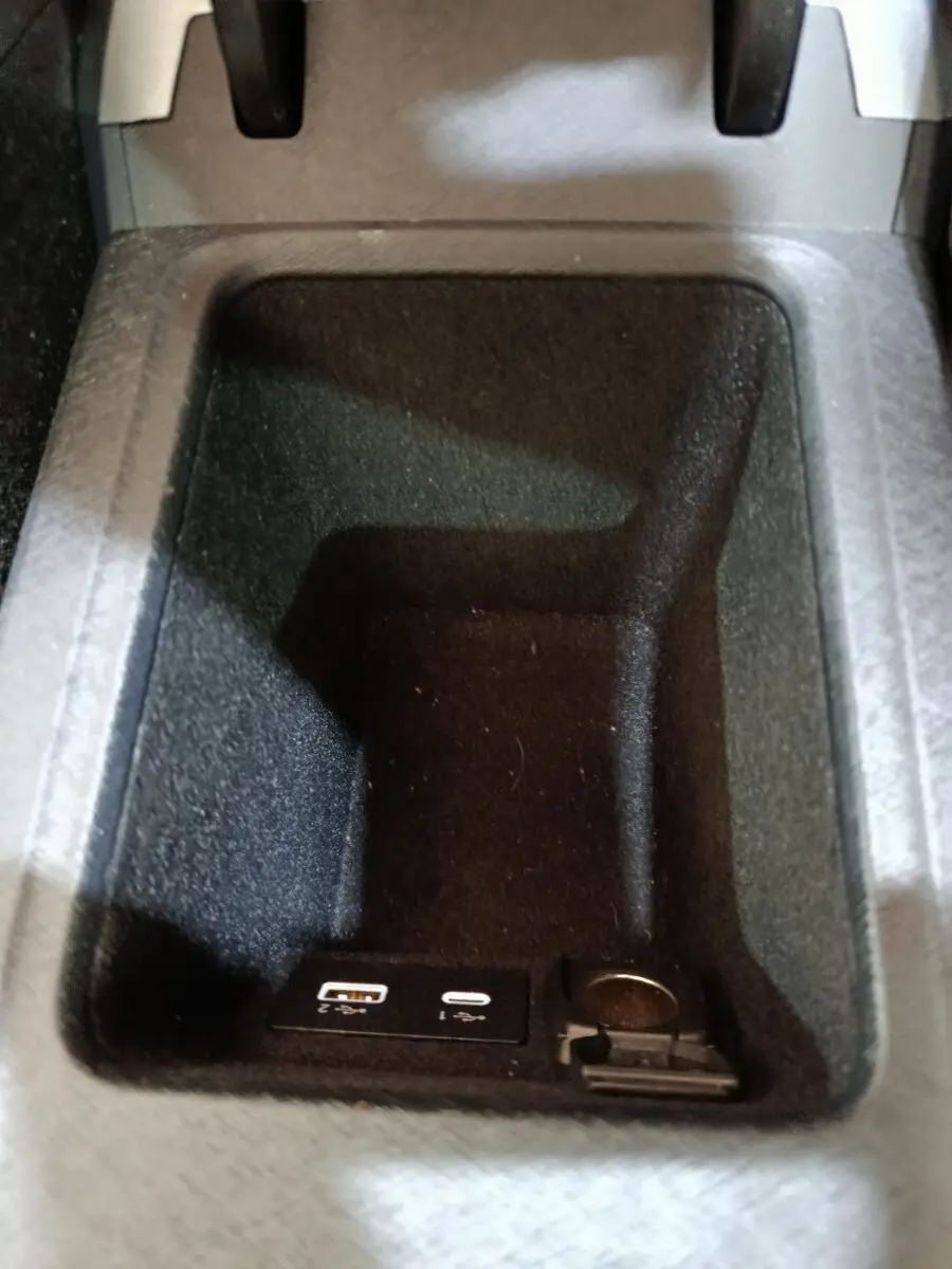 Gros plan sur le rangement central noir avec ports USB et prise 12V du LINK & CO 01 hybride rechargeable.