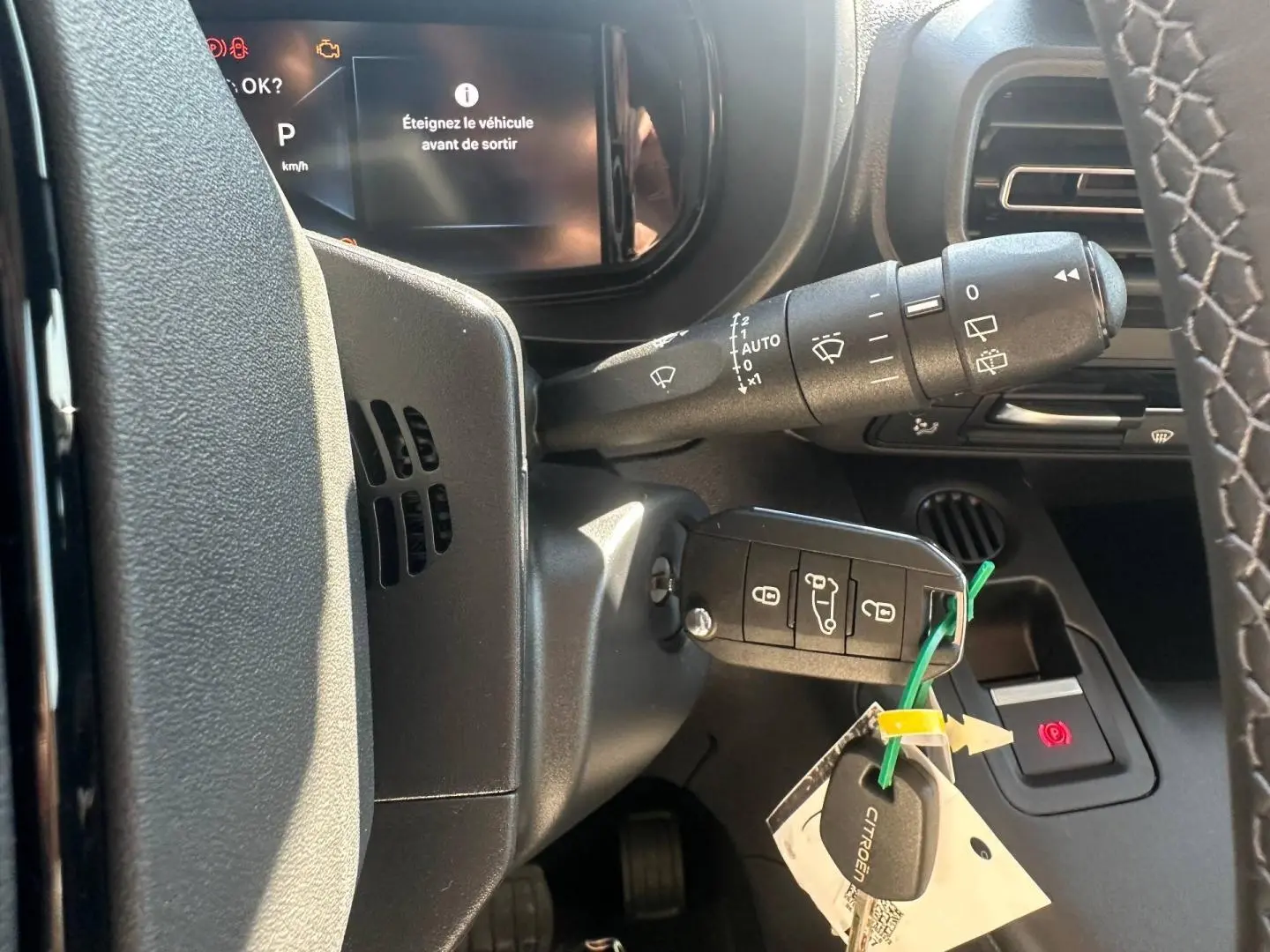 Vue rapprochée de la colonne de direction du Citroën Berlingo 2026, avec clé insérée et commandes d’essuie-glace visibles.