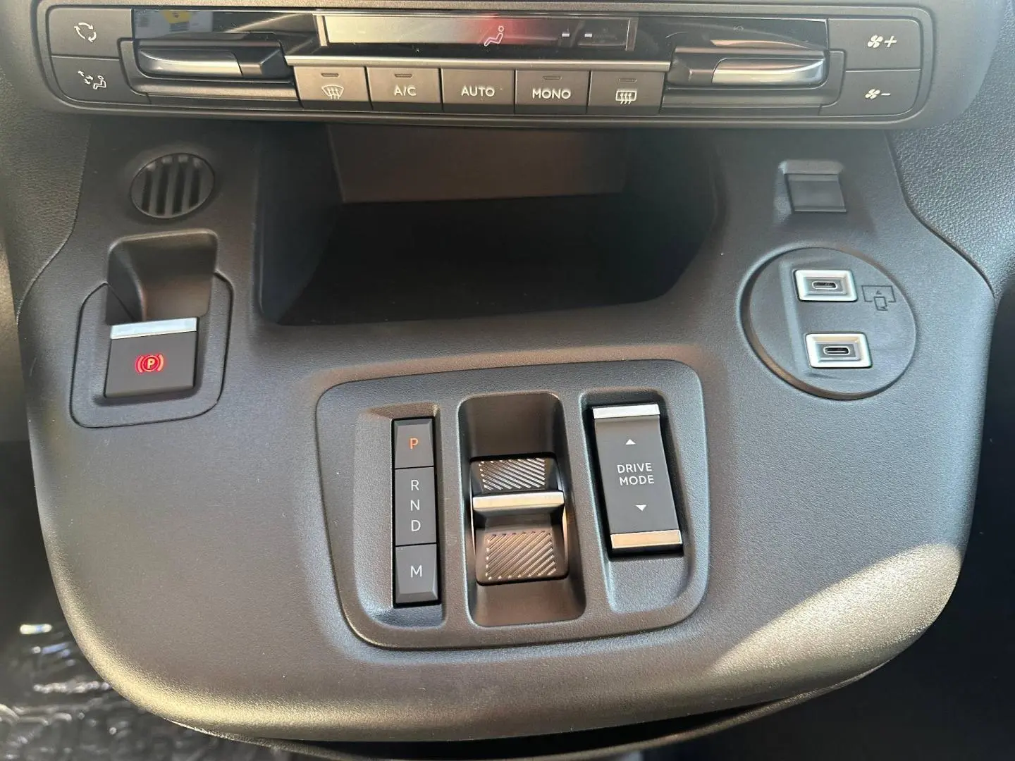 Gros plan sur la console centrale noire du Citroën Berlingo 2026 avec commandes boîte auto et ports USB visibles.