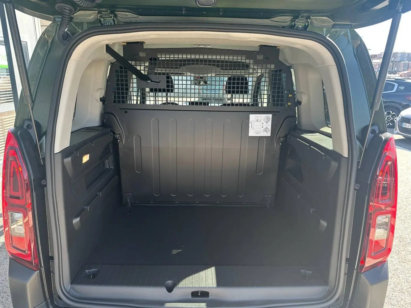 Vue arrière du Citroën Berlingo Sirkka Green avec coffre vide et cloison métallique séparant l’habitacle.