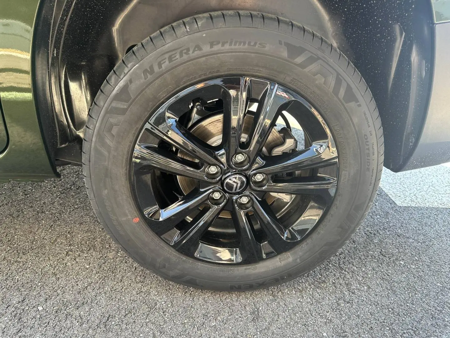 Gros plan sur la roue avant droite du Citroën Berlingo Sirkka Green avec jante alu noire brillante.