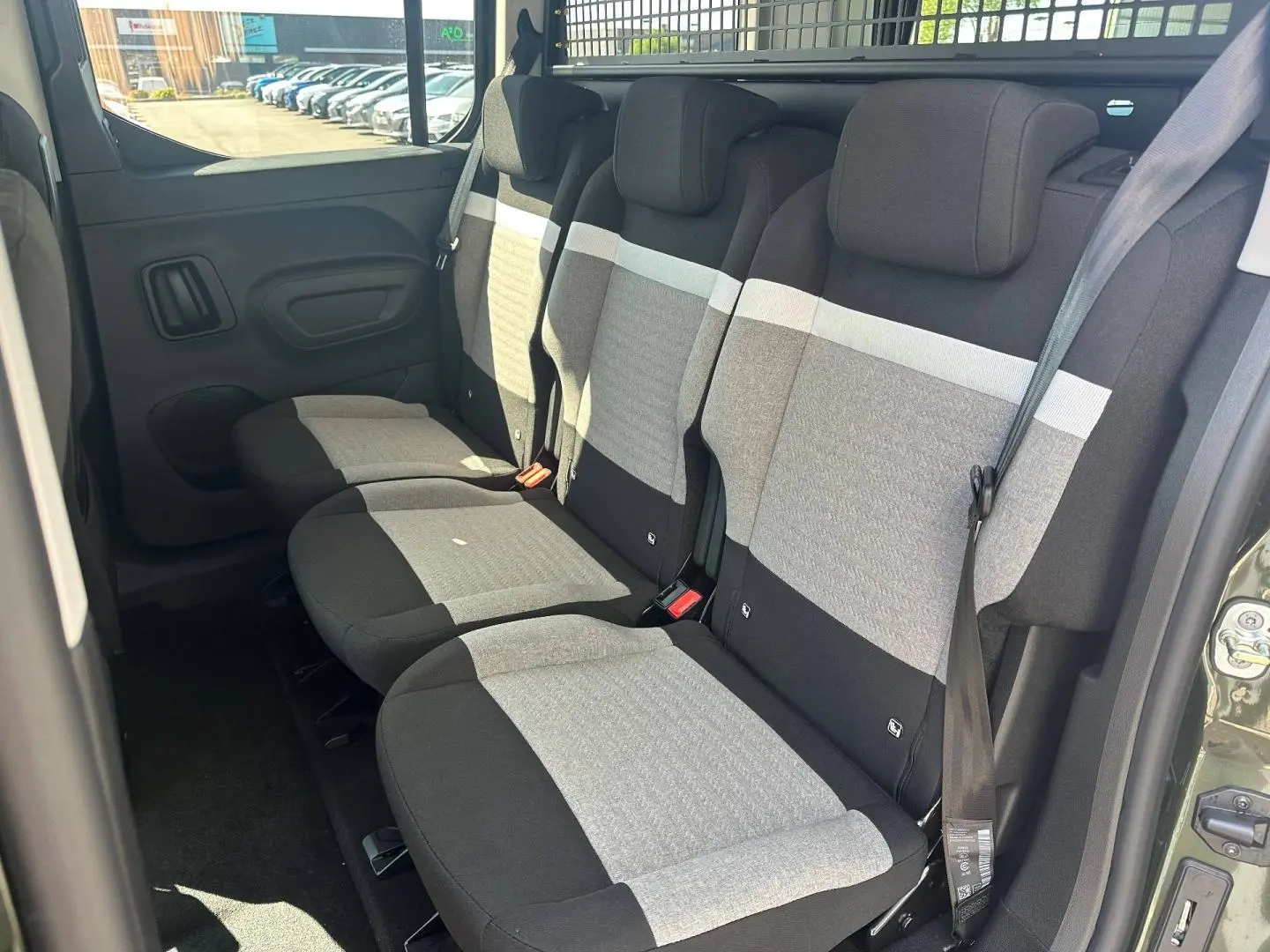 Vue intérieure côté droit des trois sièges individuels arrière gris et noir du Citroën Berlingo Sirkka Green 2026.