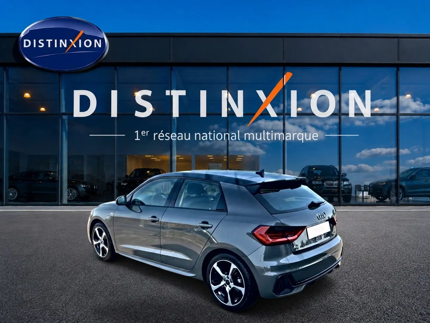 Audi A1 Sportback 30 TFSI S line gris chronos vue 3/4 arrière droit avec jantes alu et becquet noir.