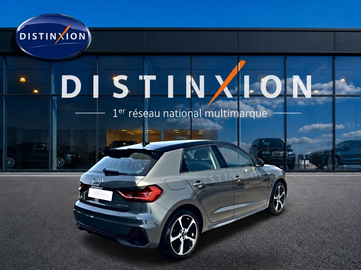 Audi A1 Sportback gris chronos vue 3/4 arrière droit avec jantes alu et toit noir devant showroom Distinxion.