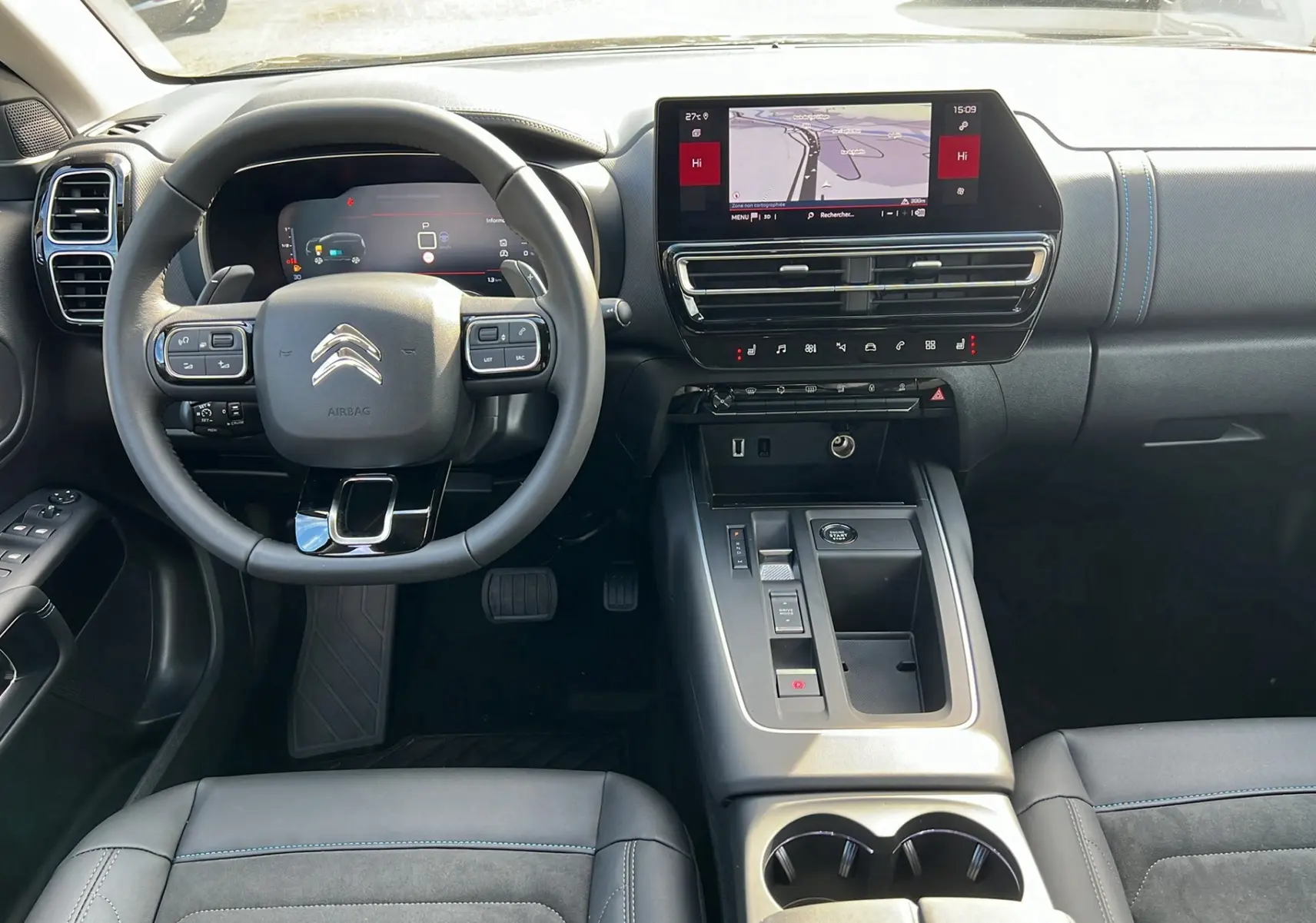 Intérieur noir du Citroën C5 Aircross Hybrid 2025, vue frontale sur le volant, tableau de bord digital et console centrale moderne.