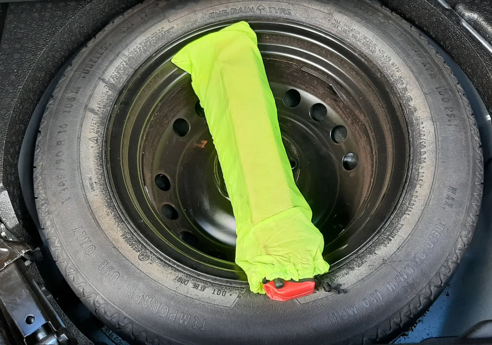 Roue de secours et cric dans le coffre d'un Renault Kadjar gris 2018, vue plongeante sur le compartiment.