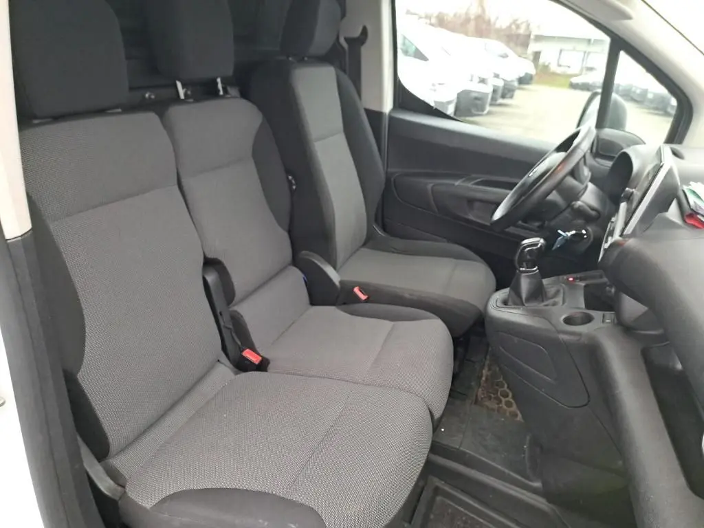 Vue intérieure côté conducteur du Citroën Berlingo blanc 2019, montrant les sièges gris et la console avec boîte manuelle.