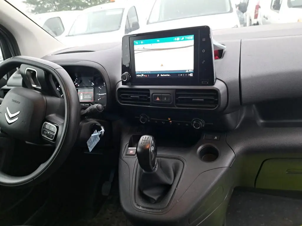 Vue intérieure côté conducteur du Citroën Berlingo blanc 2019, avec tableau de bord et écran tactile central affichant la navigation.