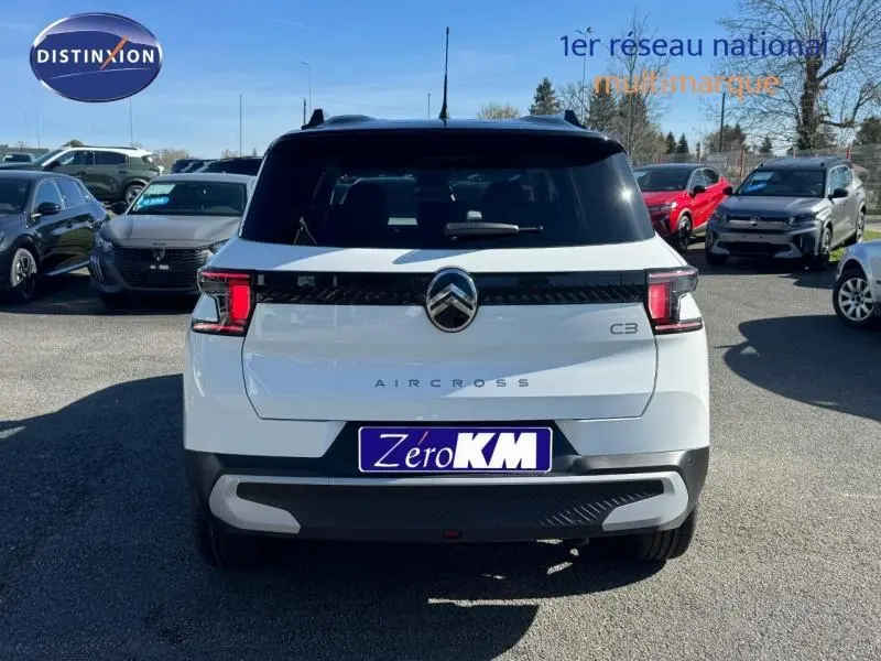 Vue arrière d'un Citroën C3 Aircross blanc Banquise avec toit noir Perla Nera, feux arrière LED et logo central distinctif.