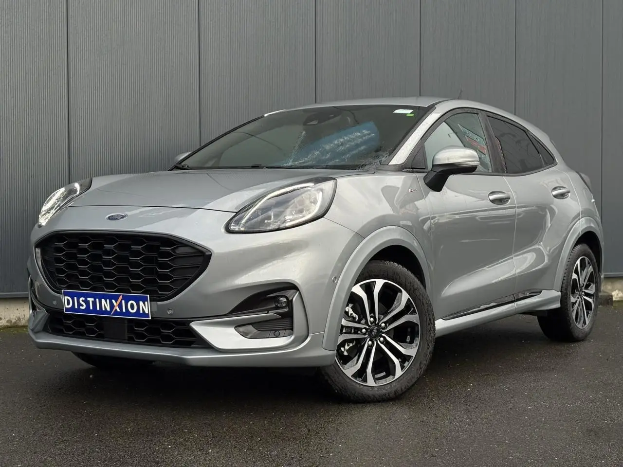 Ford Puma Ecoboost gris Solar vue 3/4 avant droit avec calandre noire et jantes alliage diamantées 17 pouces.