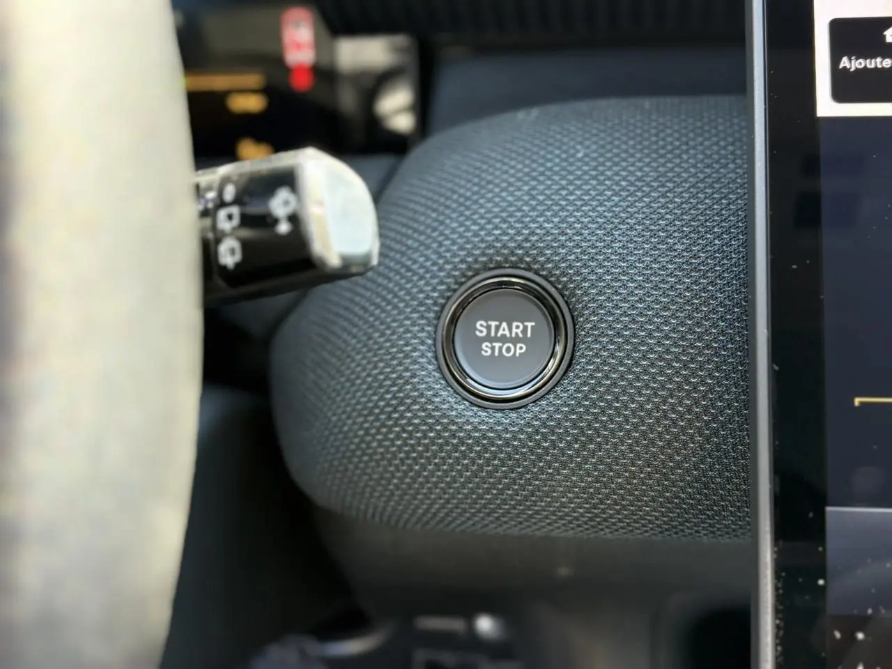 Bouton Start/Stop en gros plan sur tableau de bord texturé bleu du Citroën C5 Aircross NV Hybrid 2026.