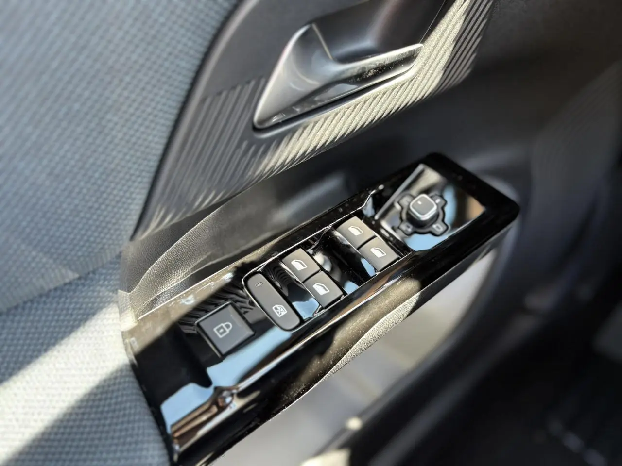 Gros plan sur les commandes de lève-vitres et rétroviseurs côté gauche d’une Citroën C5 Aircross noir Perla.