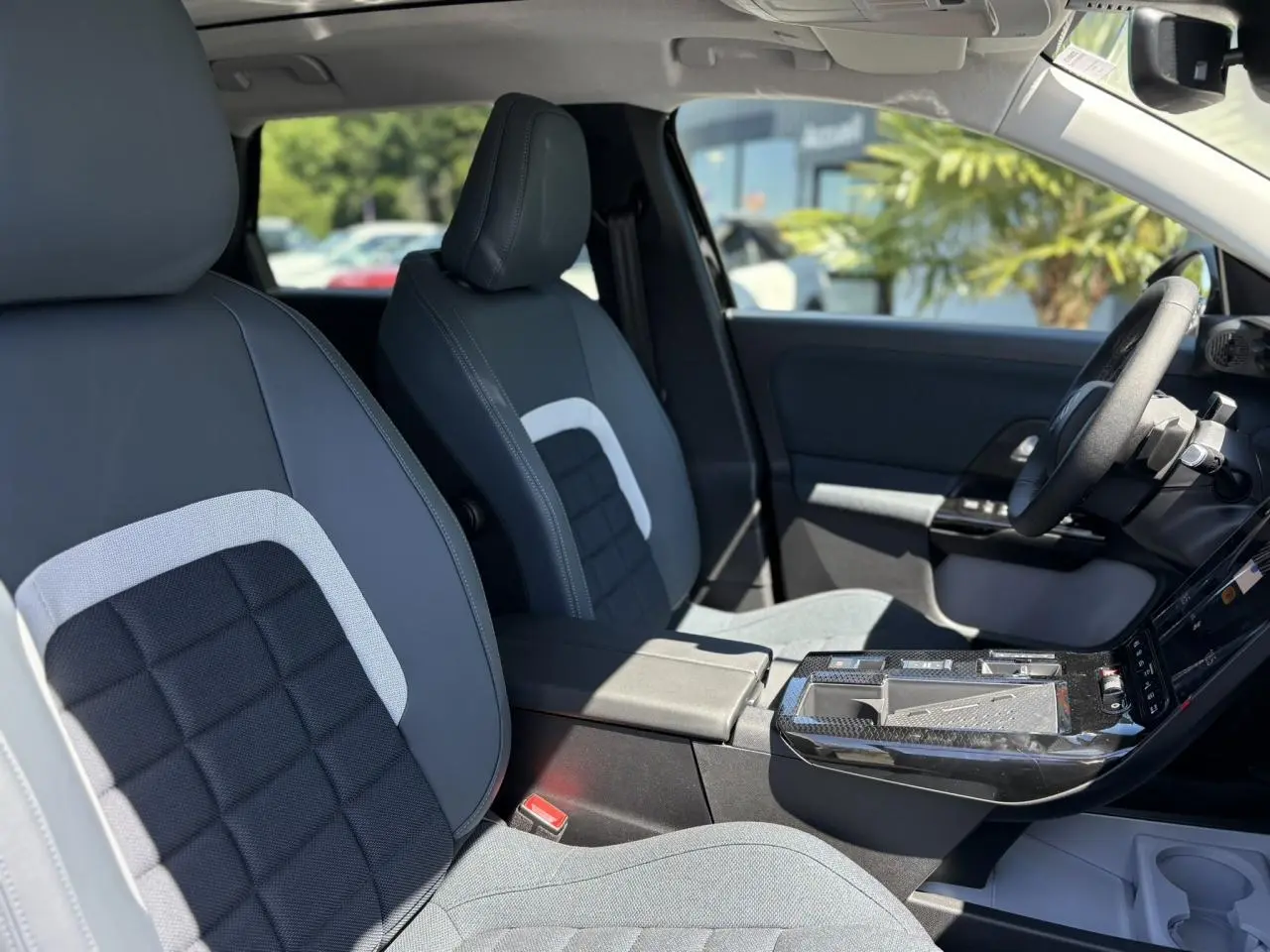 Vue intérieure côté conducteur du Citroën C5 Aircross noir Perla, sièges tissu bleu avec console centrale et volant multifonctions.