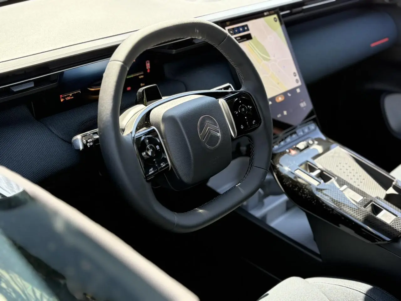 Vue rapprochée de l’intérieur du Citroën C5 Aircross hybride, volant multifonctions noir et écran tactile vertical.