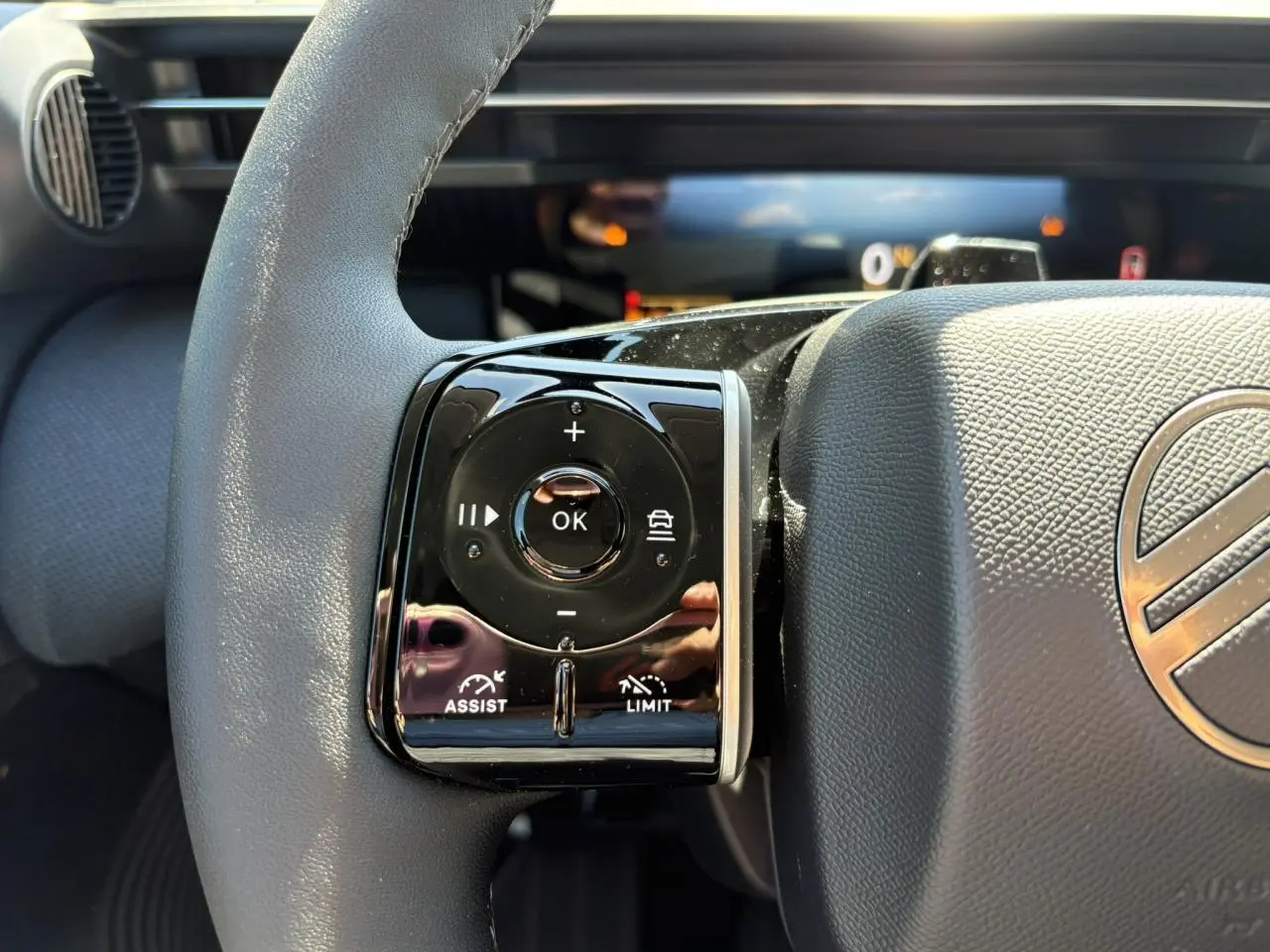 Gros plan sur les commandes multifonctions noires à gauche du volant gris du Citroën C5 Aircross 2026.
