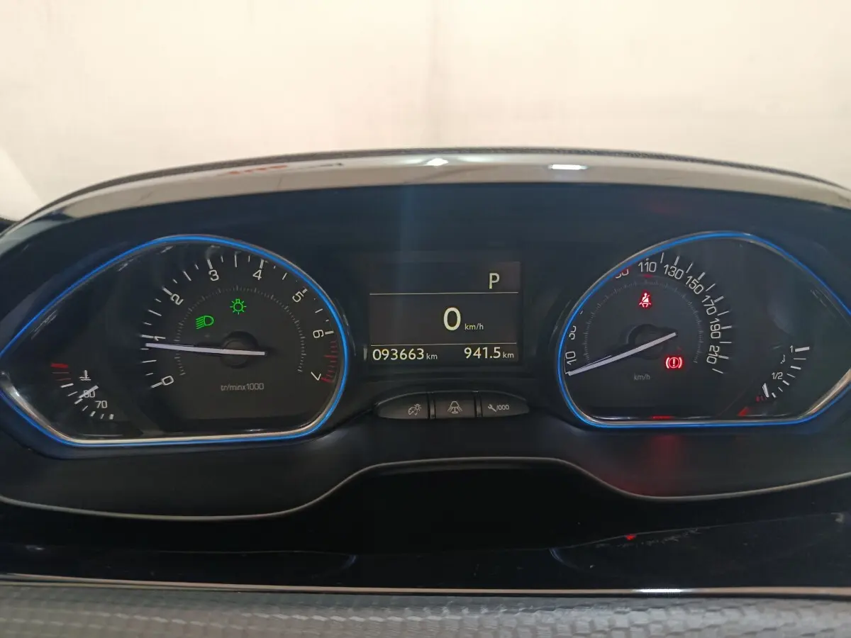 Vue rapprochée du tableau de bord numérique du Peugeot 2008 gris foncé, affichant 93663 km et indicateurs allumés.