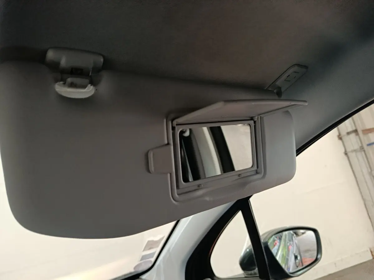 Détail du pare-soleil côté conducteur avec miroir de courtoisie ouvert dans une Peugeot 2008 gris foncé.