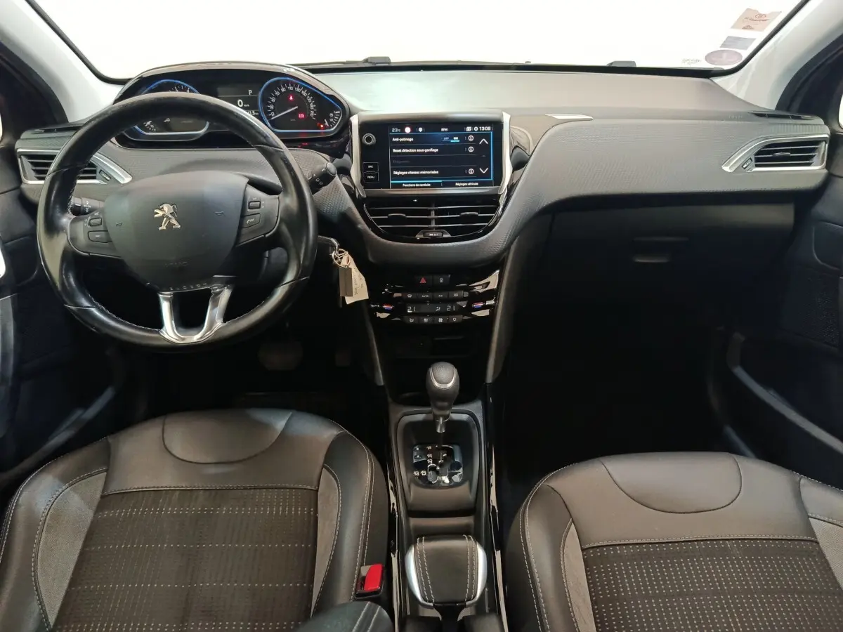 Vue intérieure avant du Peugeot 2008 gris foncé, volant cuir multifonctions et écran tactile central 7 pouces.