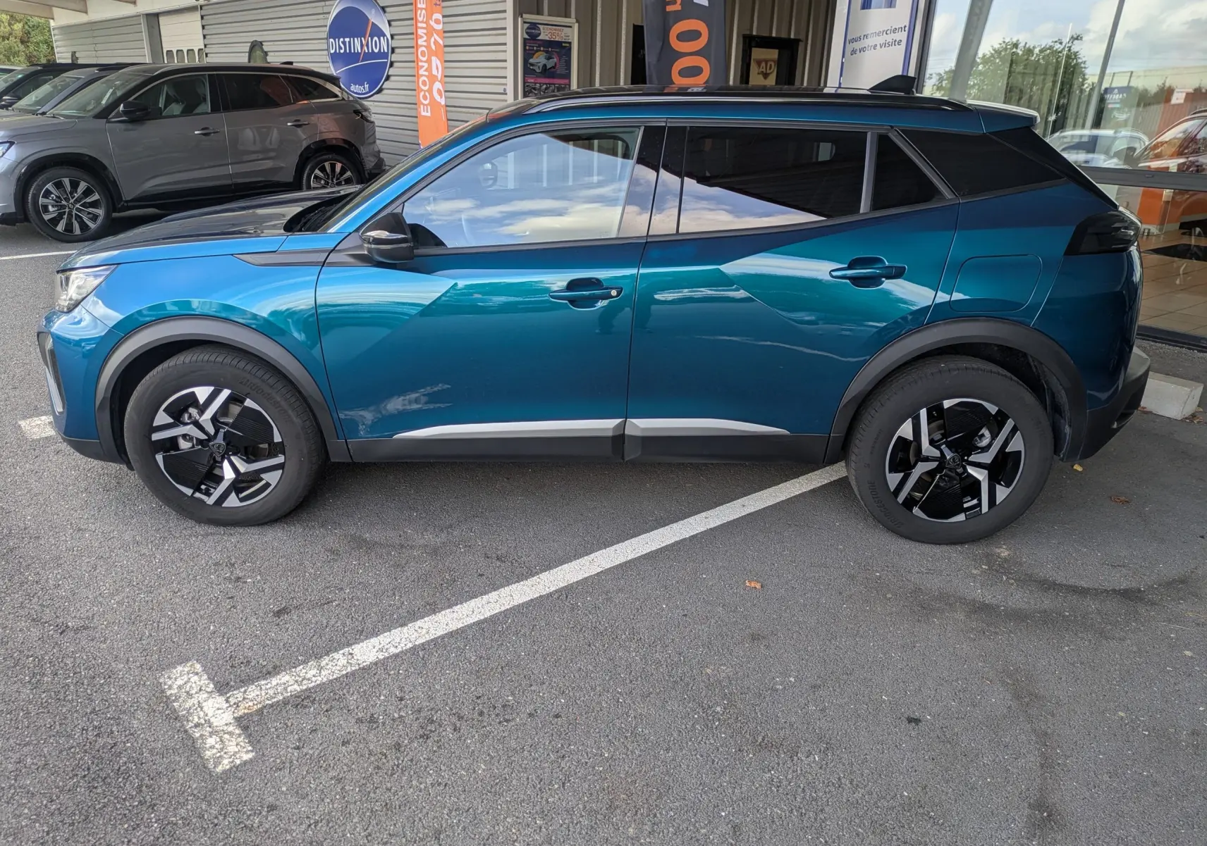 Peugeot 2008 Hybrid 145 bleu obsession en vue profil côté gauche, jantes alliage 17'' et vitres surteintées.