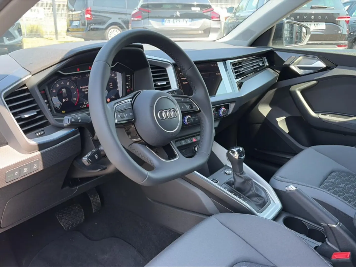 Intérieur Audi A1 Sportback 2026 vu côté conducteur, volant cuir multifonction et console centrale moderne.