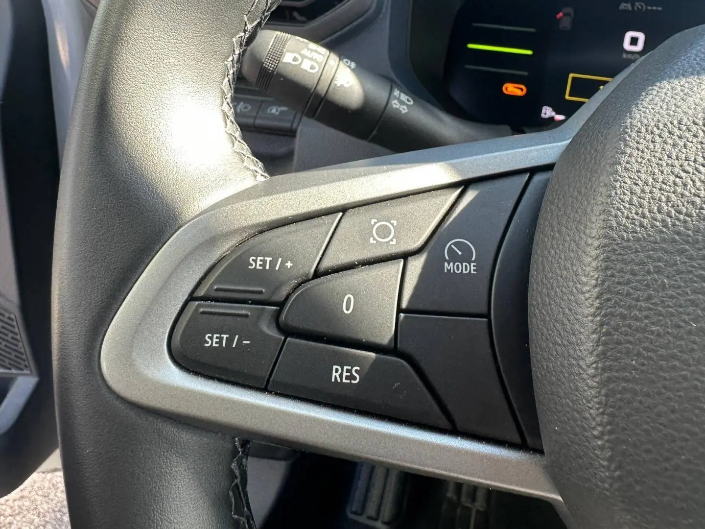 Gros plan sur les commandes du volant multifonction noir et gris du Dacia Duster 2025, version Journey Sandstone.