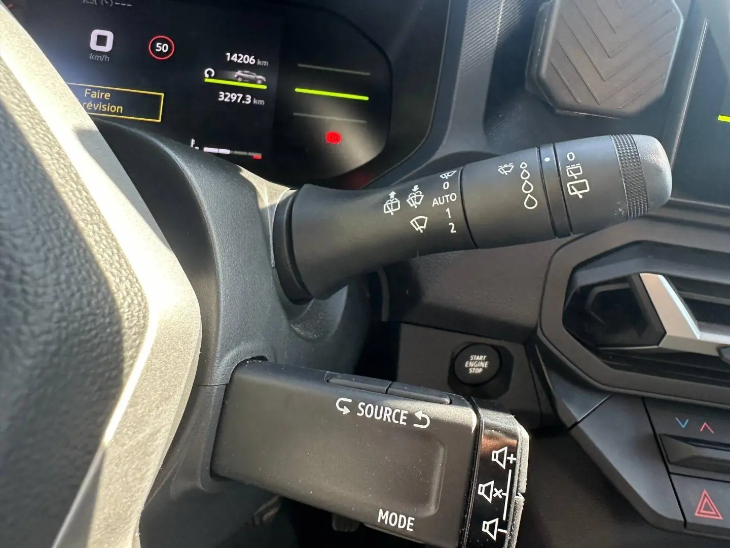 Gros plan sur la commande multifonction et le commodo d’essuie-glace du tableau de bord du Dacia Duster 2025.
