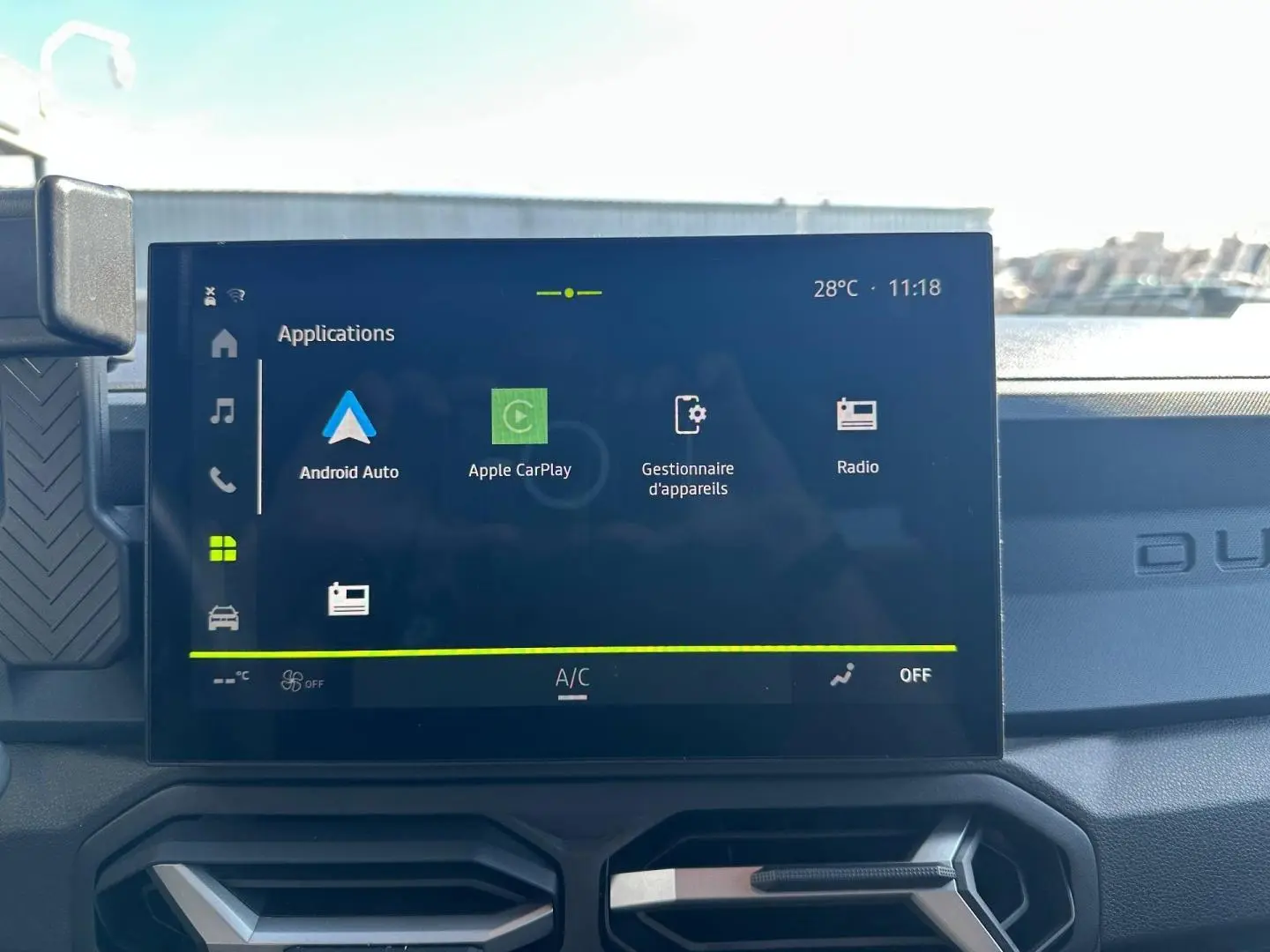 Écran tactile central du tableau de bord du Dacia Duster 2025, affichant les applications Android Auto et Apple CarPlay.
