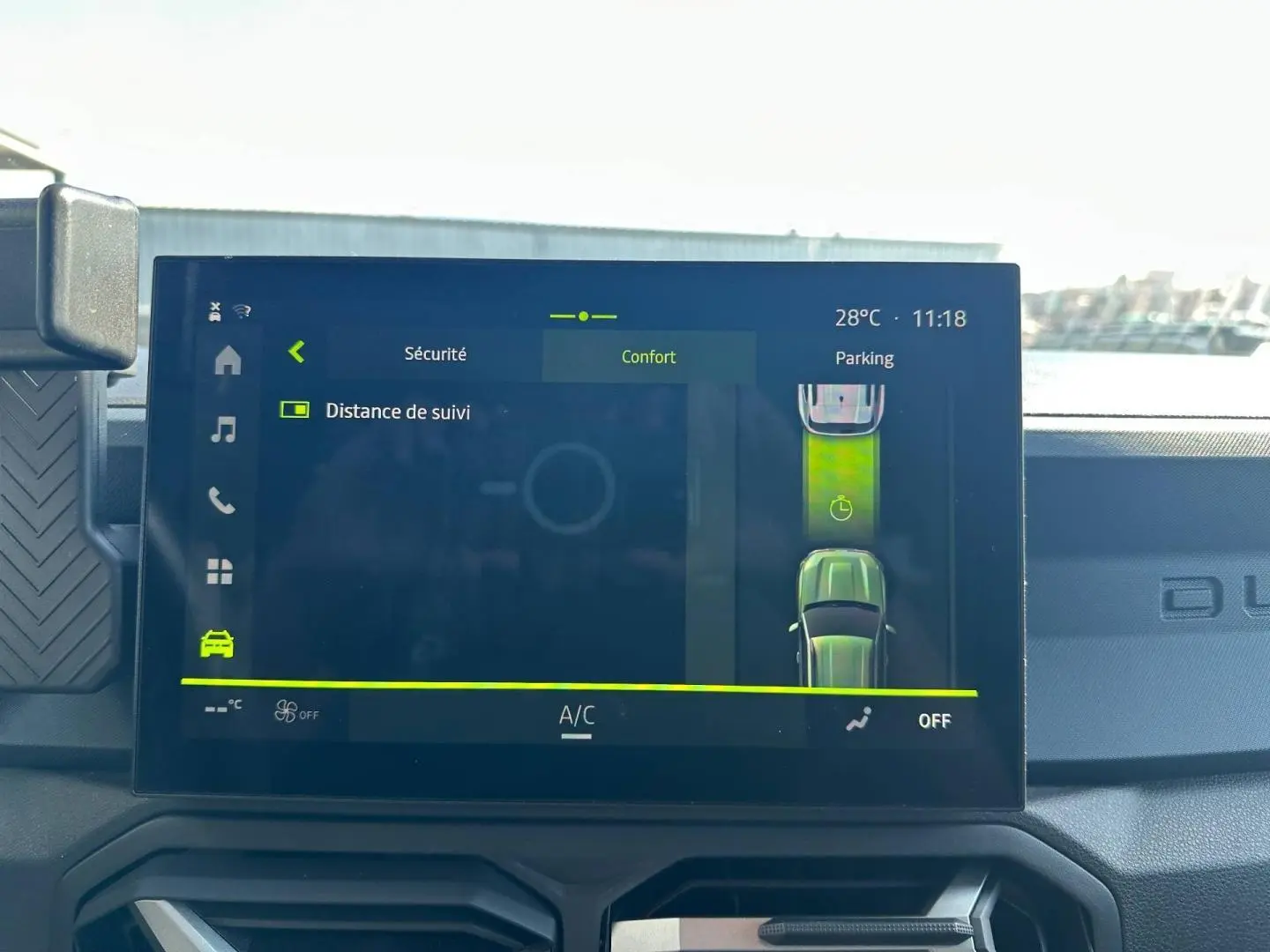 Écran tactile intérieur du Dacia Duster 2025 affichant l'assistance parking et la température à 28°C.