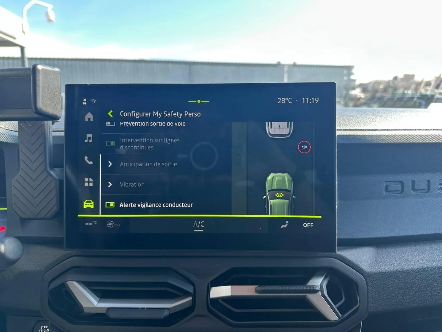 Vue intérieure du tableau de bord du Dacia Duster 2025 avec écran tactile affichant les réglages de sécurité, ambiance sobre.