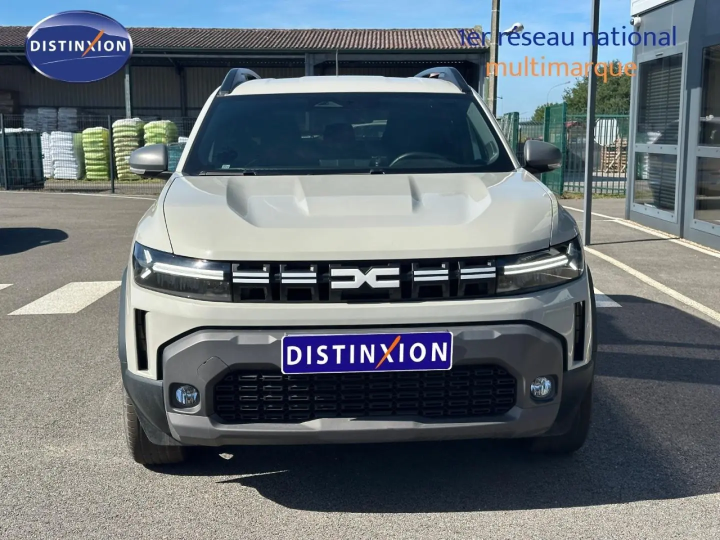 Vue frontale d'un Dacia Duster 2025 couleur Sandstone avec calandre noire et phares LED fins.