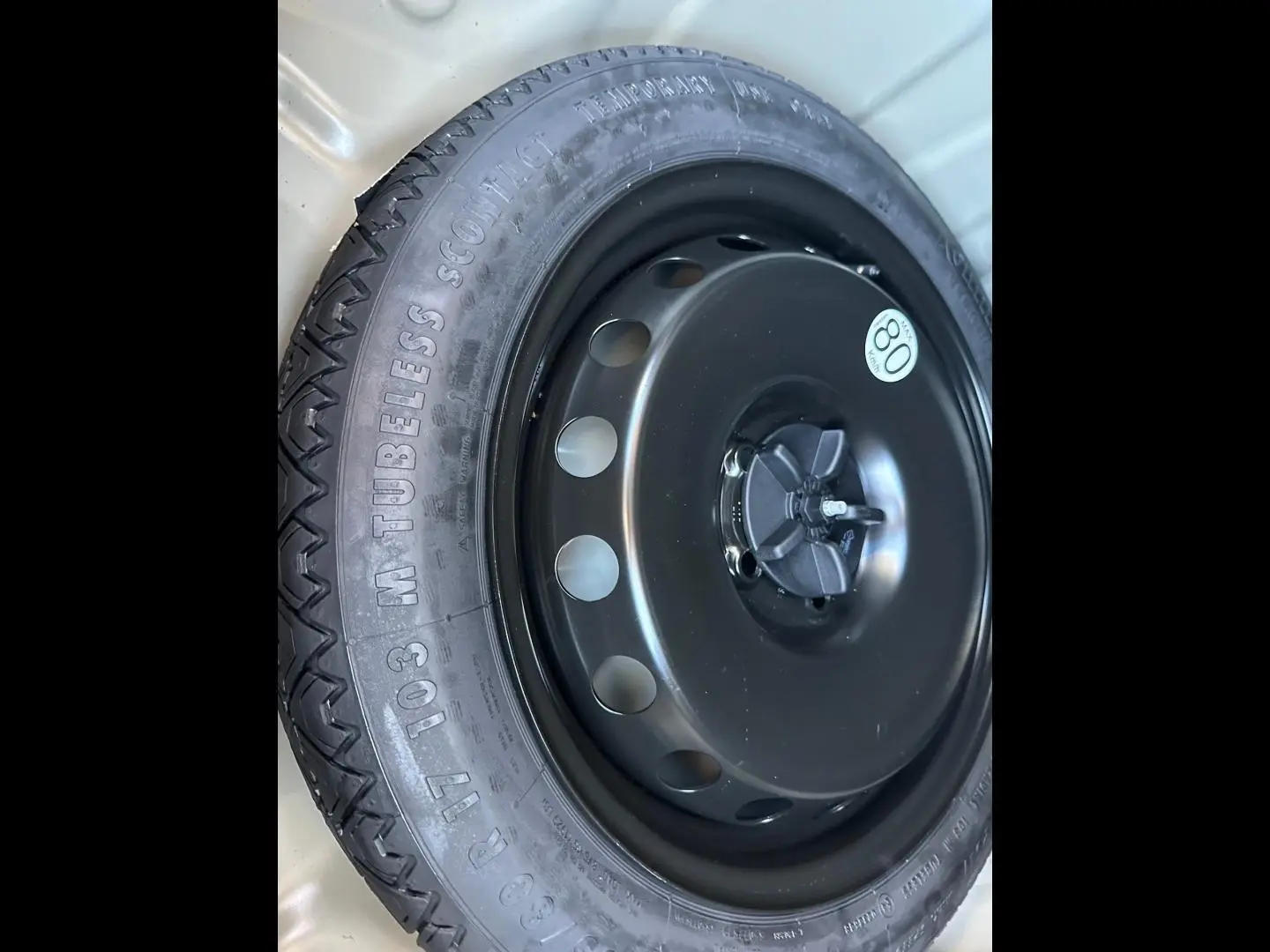 Gros plan sur la roue de secours noire du Dacia Duster 2025, avec pneu tubeless et étiquette de vitesse 80 km/h.