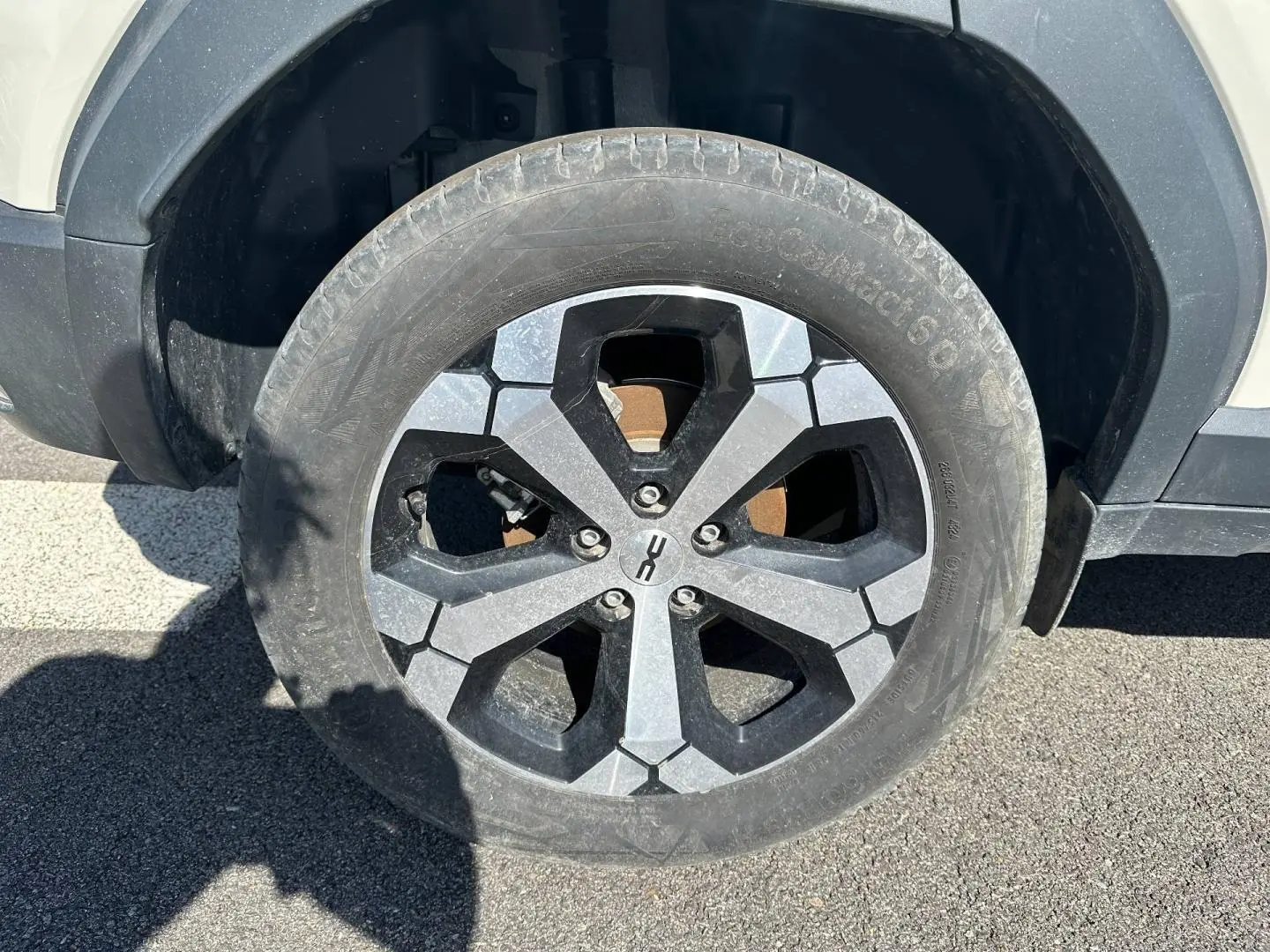 Gros plan sur la roue avant gauche du Dacia Duster 2025 couleur Sandstone avec jante alu noire et grise.