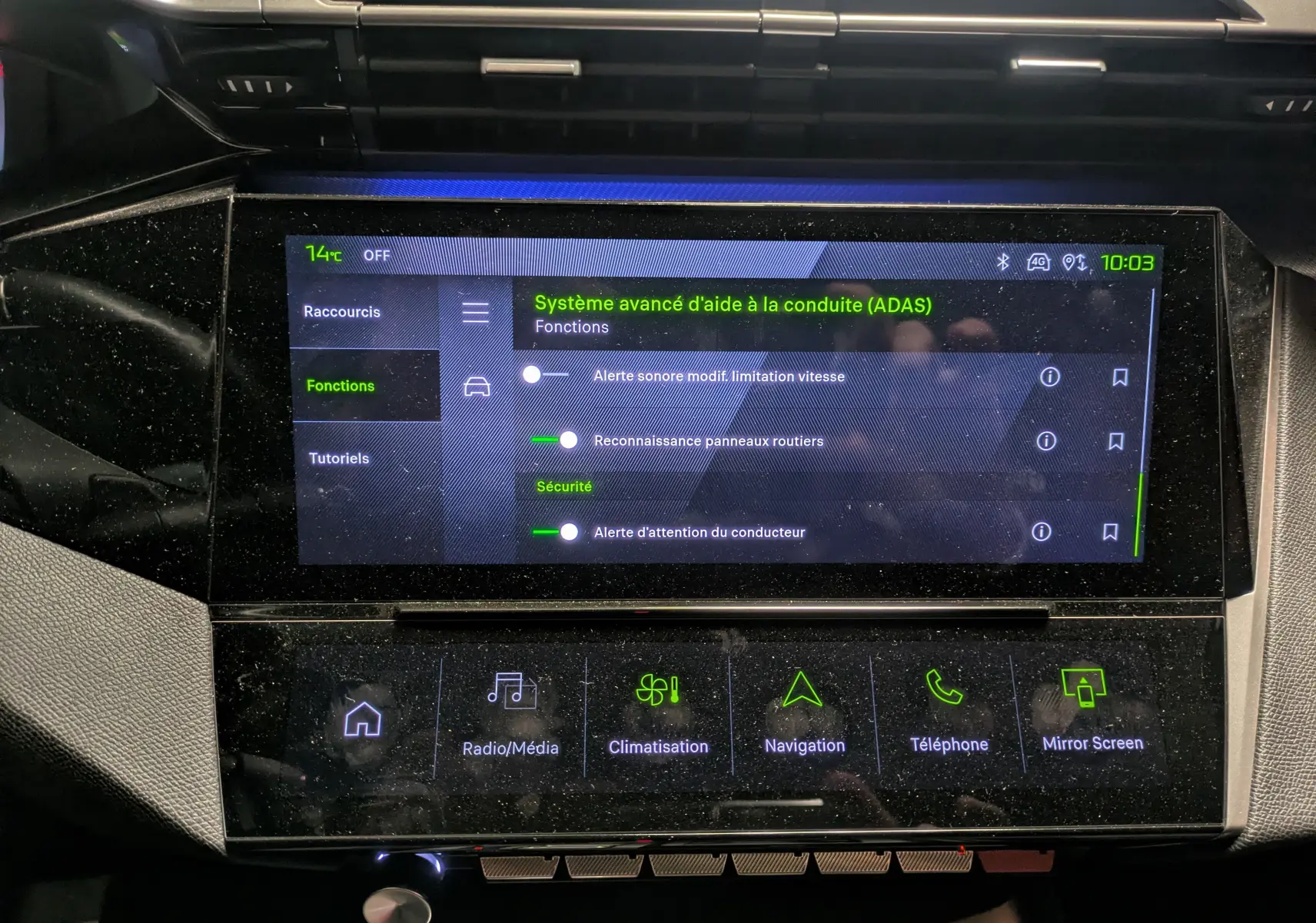 Vue rapprochée de l’écran tactile central du Peugeot 308 SW Hybrid 145 eDCS6 GT gris, affichant les fonctions d’aide à la conduite.