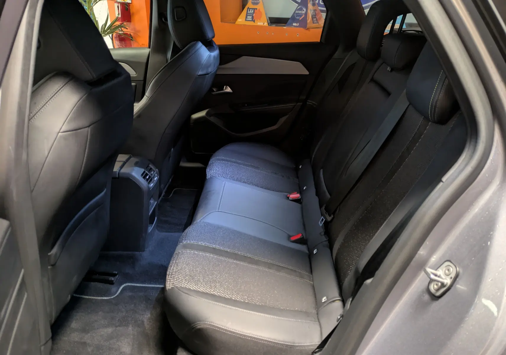 Écran intérieur de la Peugeot 308 SW Hybrid gris montrant la caméra de recul et l’aide au stationnement en vue arrière.